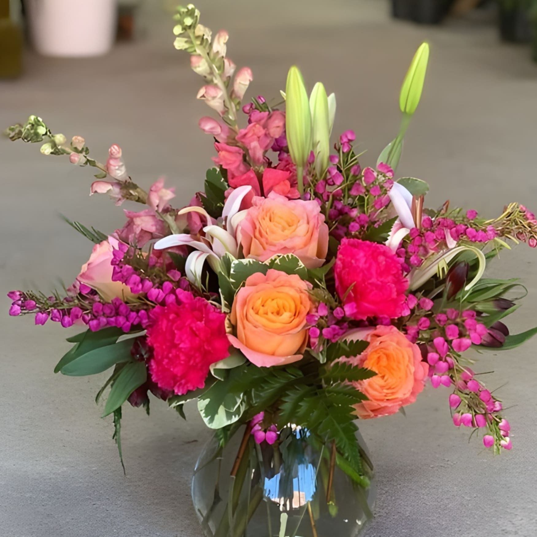 Sunset Harmony 1st - A customer favorite of warm sunset colors arranged with snapdragons, roses, lilies, and other seasonal blooms. This arrangement promises to be the highlight of someone's day.