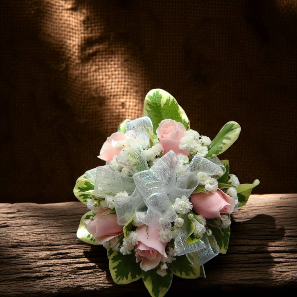 Small bouquet of pink roses with white filler and a sheer ribbon