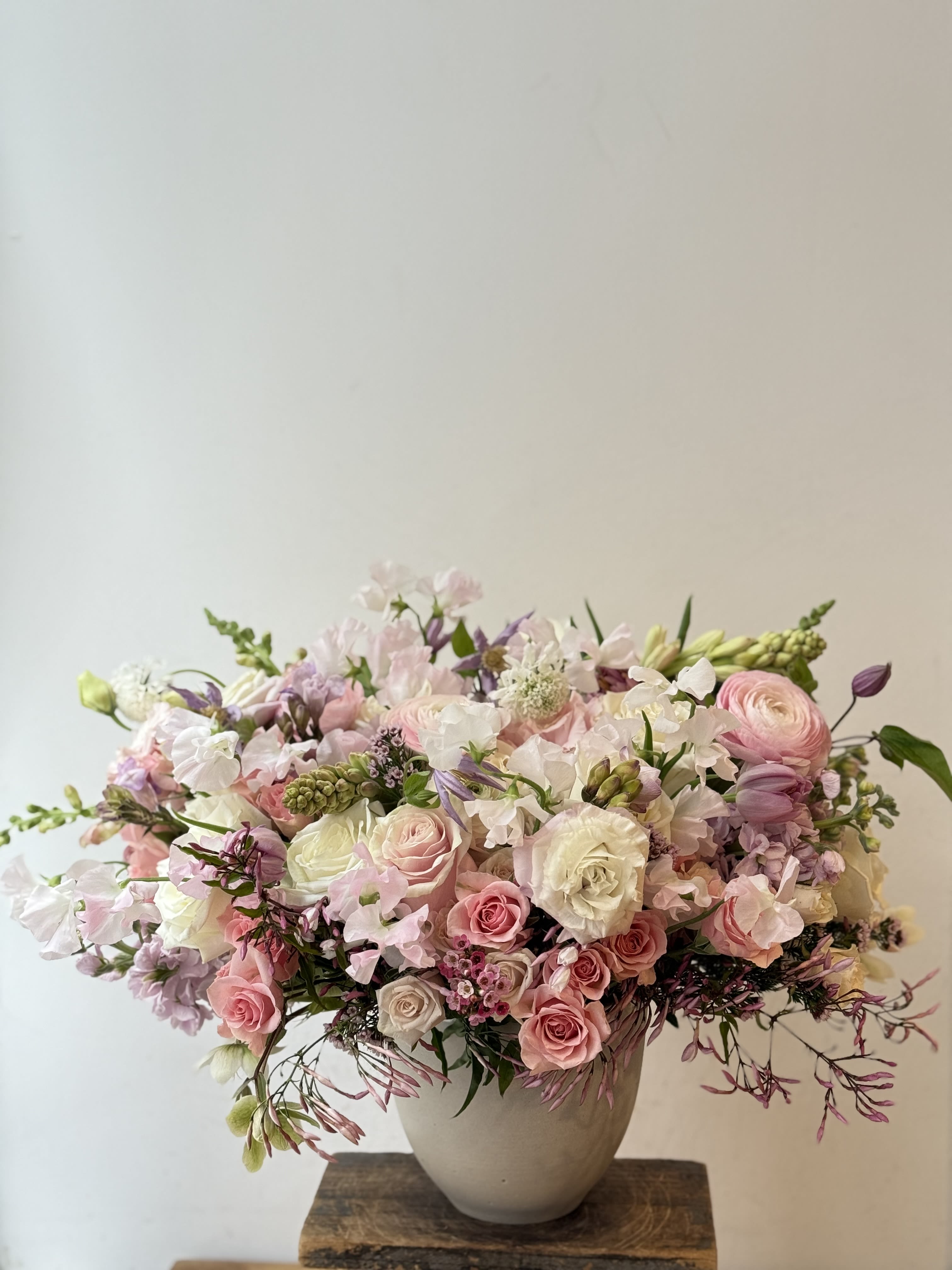 Angel - Discover the epitome of elegance and grace with our enchanting white vase, a masterpiece filled to the brim with a mesmerizing array of lush pink and white blooms. Each vase is a symphony of color, featuring a meticulously curated selection of garden roses, ranunculus, freesia, classic roses, and anemone. These flowers are not merely placed; they are thoughtfully arranged to evoke a sense of serene beauty and sophisticated charm. The pristine white vase enhances the radiance of the blooms within, creating a harmonious blend of color and light that captivates and delights. This exquisite arrangement transcends the ordinary, making it the perfect gift for special occasions or a luxurious centerpiece that will elevate any space with its breathtaking beauty. Let the allure of our pink and white floral arrangement be the expression of your impeccable taste and the embodiment of luxury in bloom from the best florist in new york.