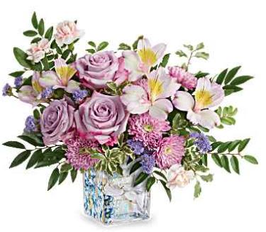 Written in the Sky - Teleflora's Written In The Sky Bouquet includes lavender roses, lavender alstroemeria, pink miniature carnations, lavender cushion spray chrysanthemums, lavender sinuata statice, huckleberry, and pitta negra, presented in Teleflora's Written In The Sky Cube, a glass cube featuring a dove and floral design. 