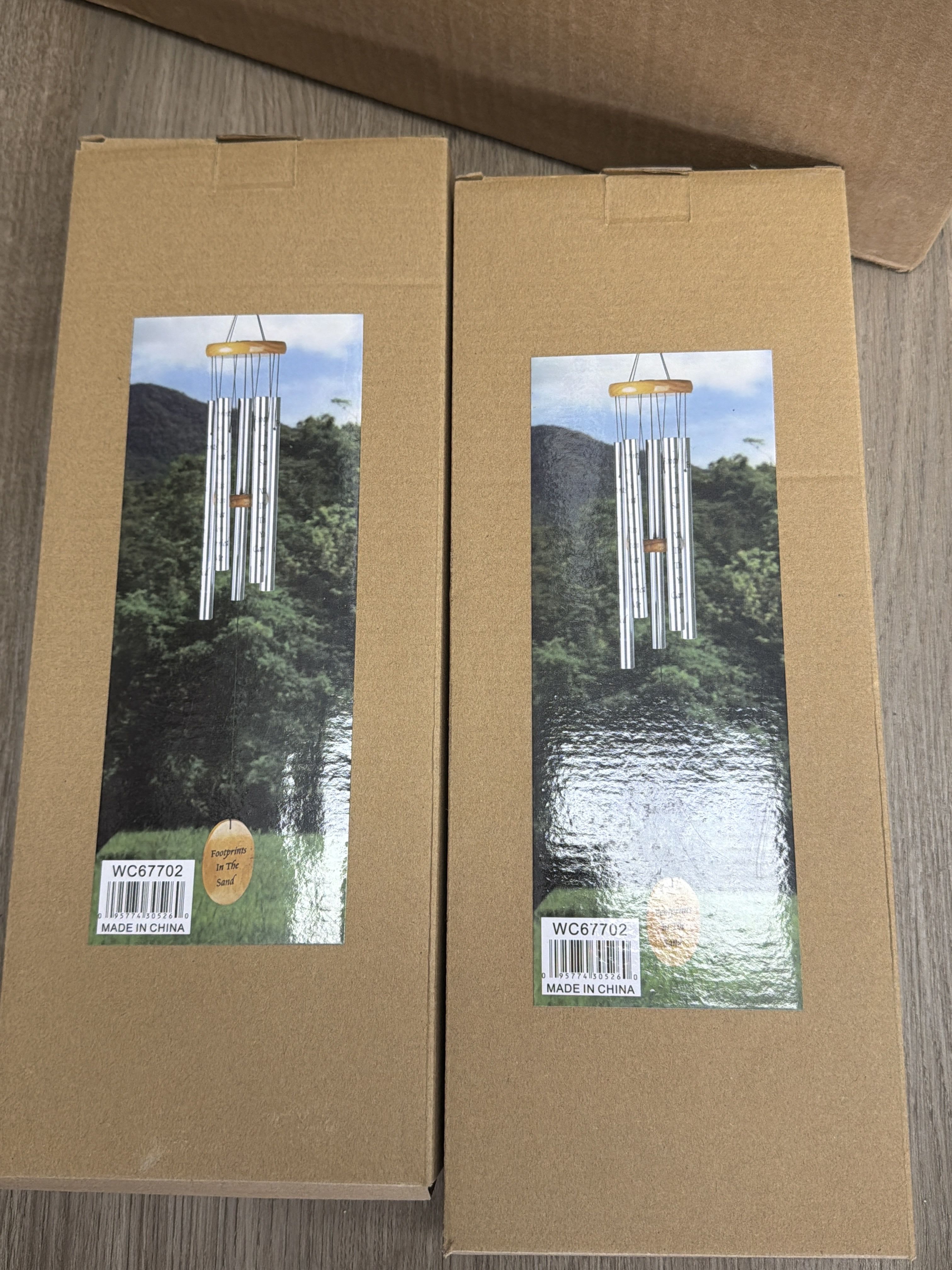 Two cardboard boxes with pictures of silver wind chimes on the front.