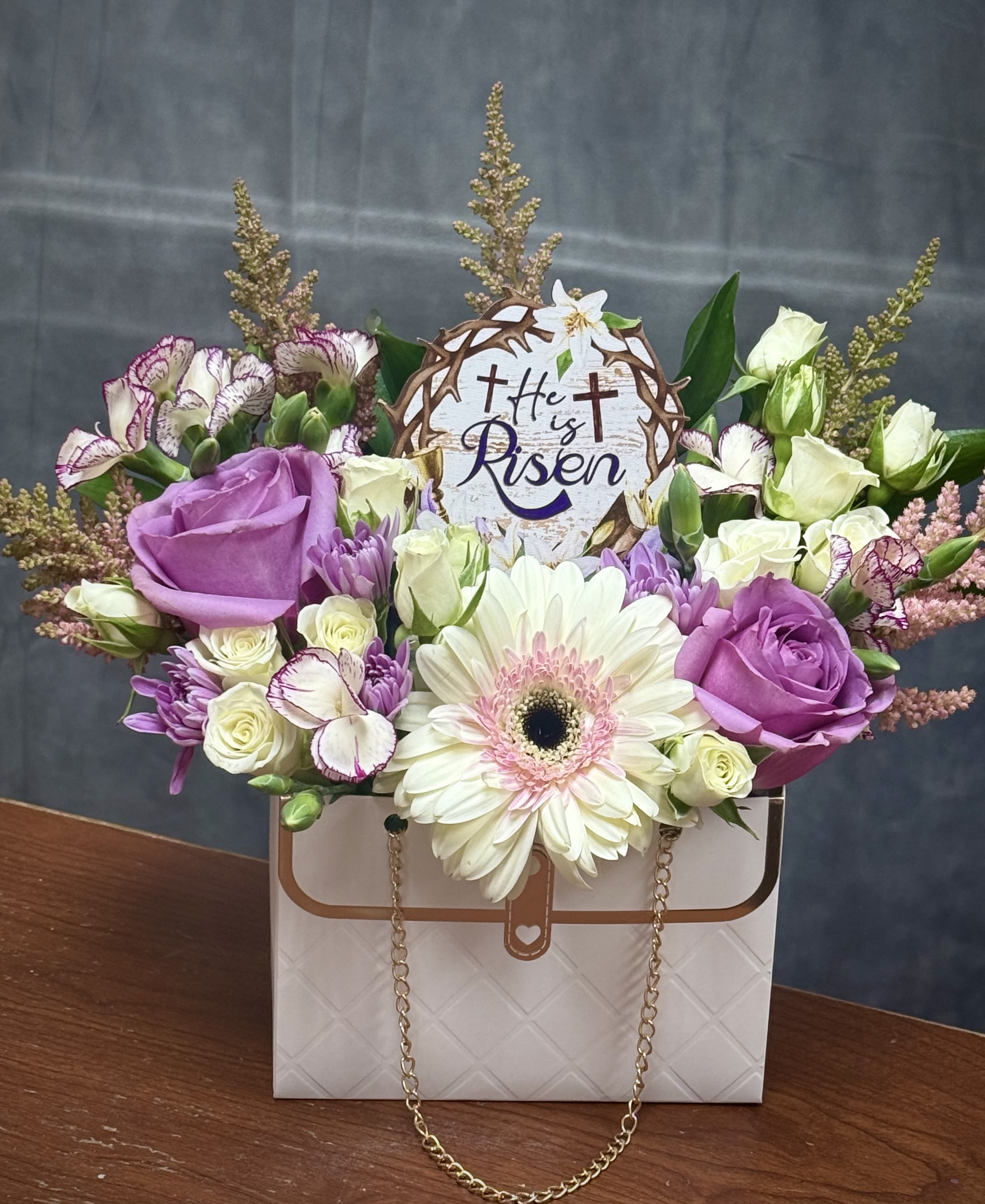 Resurrection Grace Purse  - A beautiful expression of faith and renewal, this arrangement blends pastel blooms with a symbolic centerpiece, creating a heartfelt design perfect for Easter celebrations.