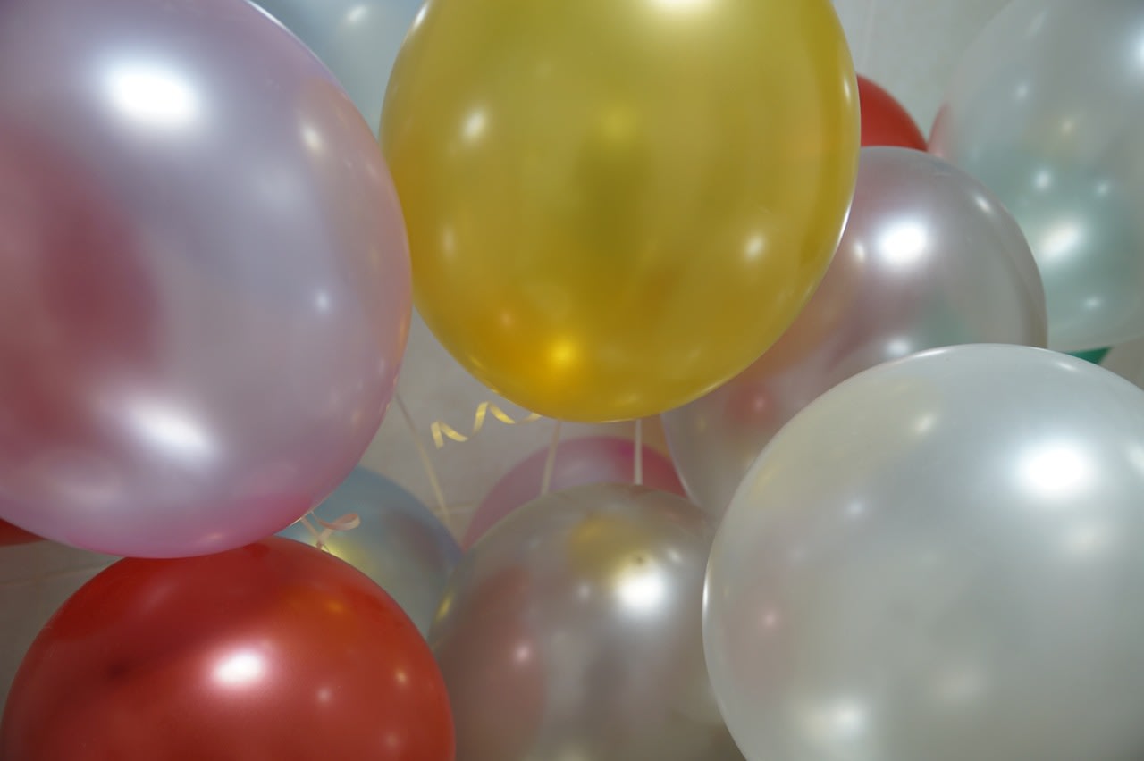 Cluster of pastel and metallic balloons in yellow, white, pink, and red tones