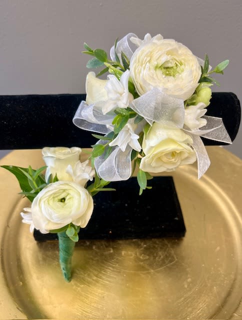 Romeo &amp; Juliet - A wristlet for her and a boutonnière for him. White roses and ranunculus adorned with white hyacinth designed on a classic band with a matching boutonniere for him.  A true classic.