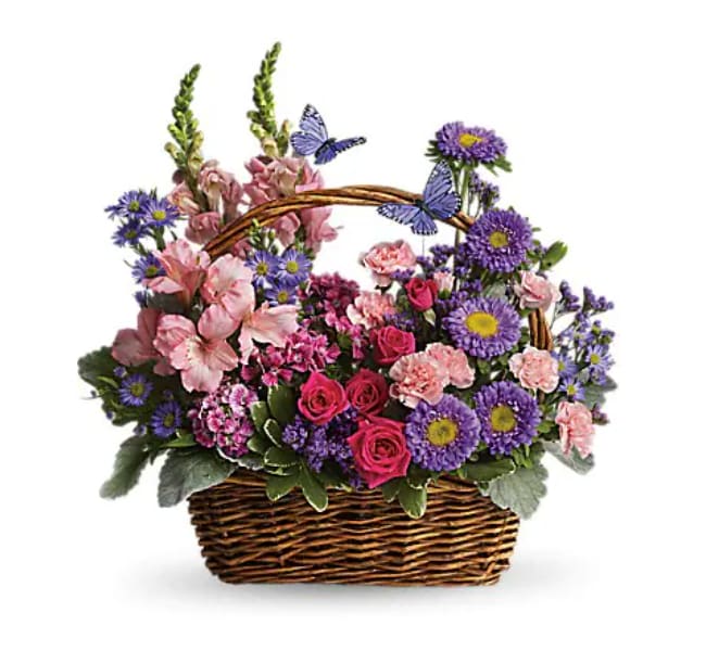 Basket arrangement of pink roses and carnations with purple asters and faux butterflies