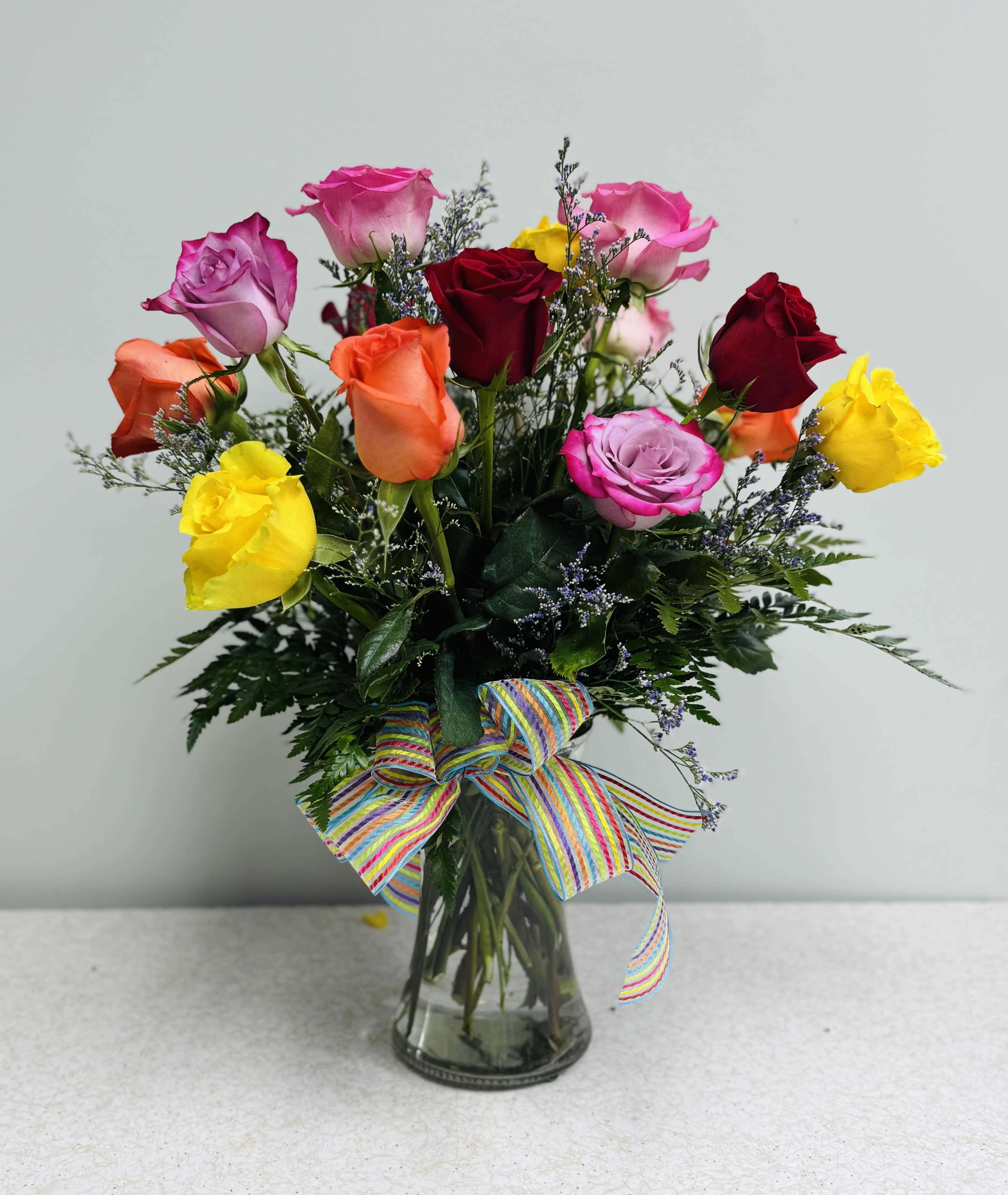 15 Roses-Skittles Bouquet - This cheery rose bouquet features 15 roses in several colors with a radiant filler! You don't get more colorful and happy than this arrangement, complete with a vibrant bow. 