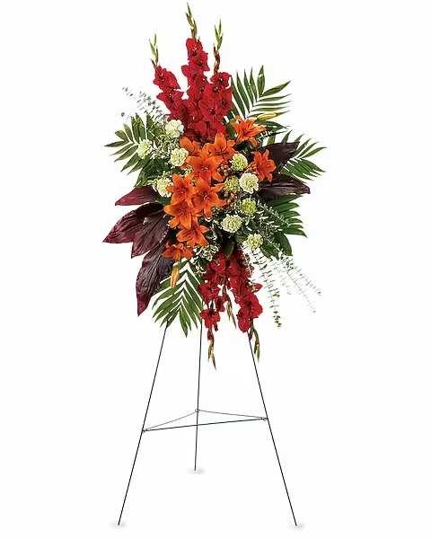 A New Sunrise Spray - When a loved one has passed, this radiant spray of red and orange flowers will be a reminder of happy times past that will never be forgotten. The stunning arrangement includes orange Asiatic lilies, red gladioli, green carnations, peach hypericum, emerald palm and red ti leaves, accented with assorted greenery.