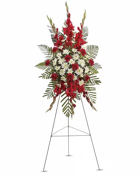 Strength &amp; Solace Spray - Express your love beautifully and tastefully with this stunning spray of red and white floral favorites. An impeccable choice for the memorial service. The magnificent spray includes red gladioli, red carnations and white cushion spray chrysanthemums, accented with emerald palm and leatherleaf fern.