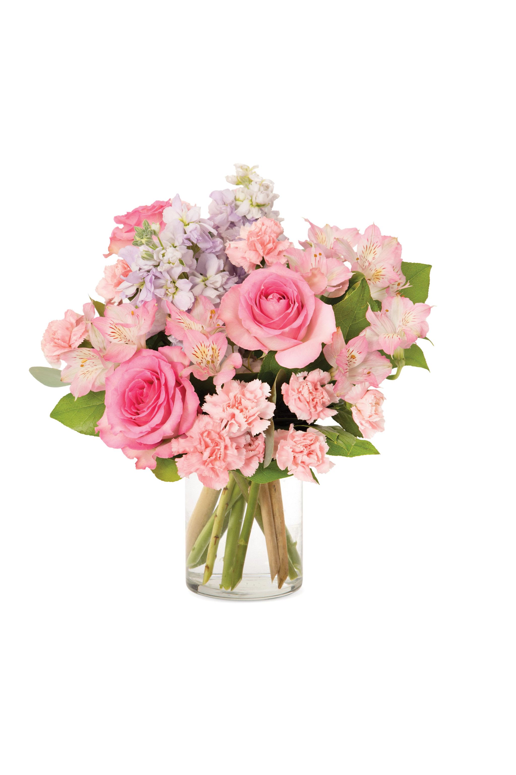 Pink rose, carnation, and alstroemeria bouquet with lavender stock in a clear glass vase