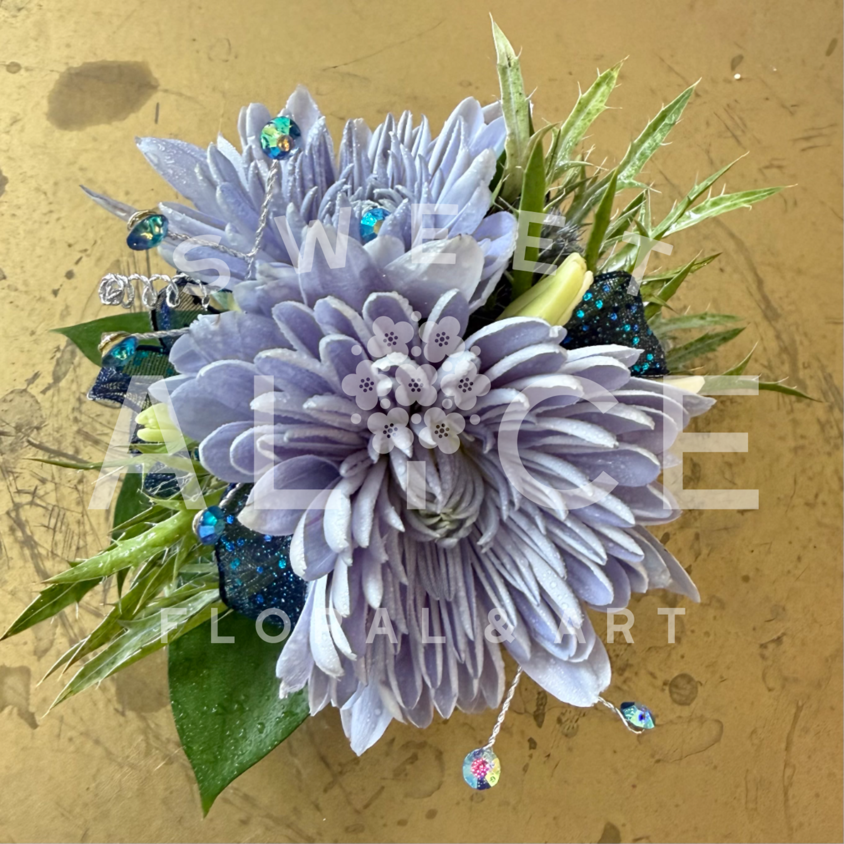 Cosmic Corsage - Lovely chrysanthemum flowers with ribbon, gemstones and greens.  Built onto a lovely silk ribbon wristband that ties to accommodate any wrist size.  Please note specific color requests in the notes section of your order.  * Corsage only.