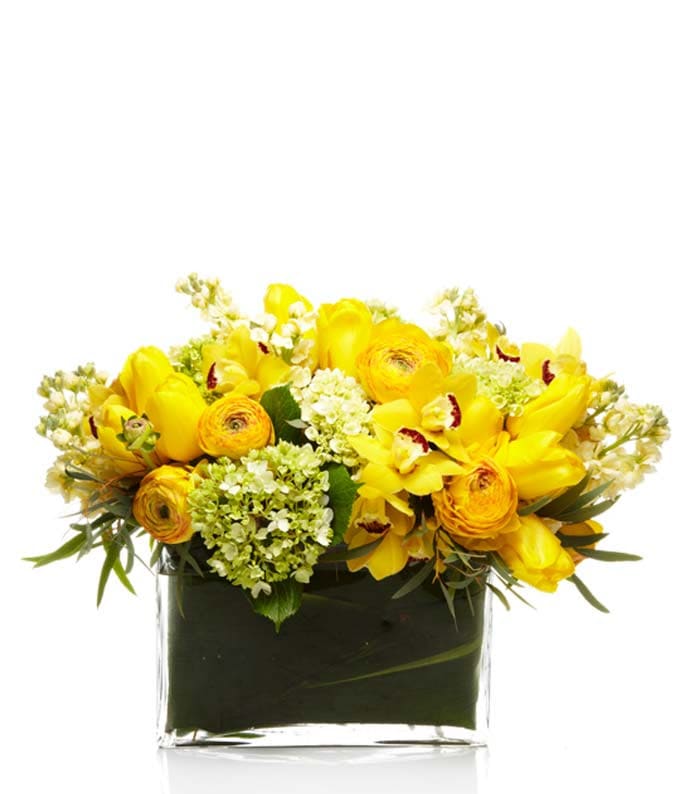 Low yellow flower arrangement in a rectangular clear glass vase