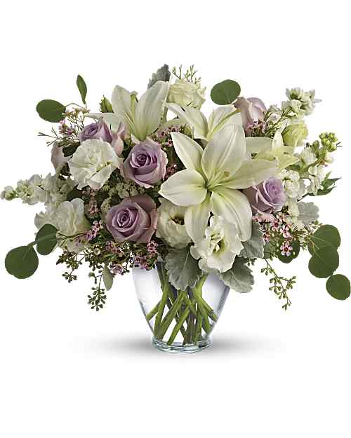 Lovely Luxe - Luxe in love! Pale lavender roses, creamy white lilies and delicate greens create a soft, romantic bouquet that's as tender as your feelings. Lavender roses, white asiatic lilies, white lisianthus, white stock, lavender waxflower, and white sinuata statice are accented with dusty miller, seeded eucalyptus, and silver dollar eucalyptus.