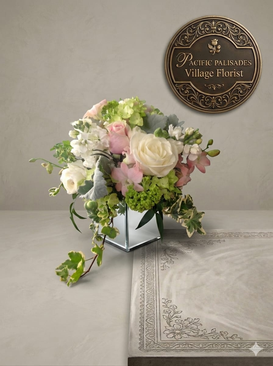 Princess Ivy - A soft, romantic arrangement in delicate blush and ivory tones, featuring classic roses paired with airy white blooms and fresh green accents, all complemented by trailing variegated ivy. The design feels light and graceful, with a natural, garden-inspired style that blends elegance with a touch of whimsy.