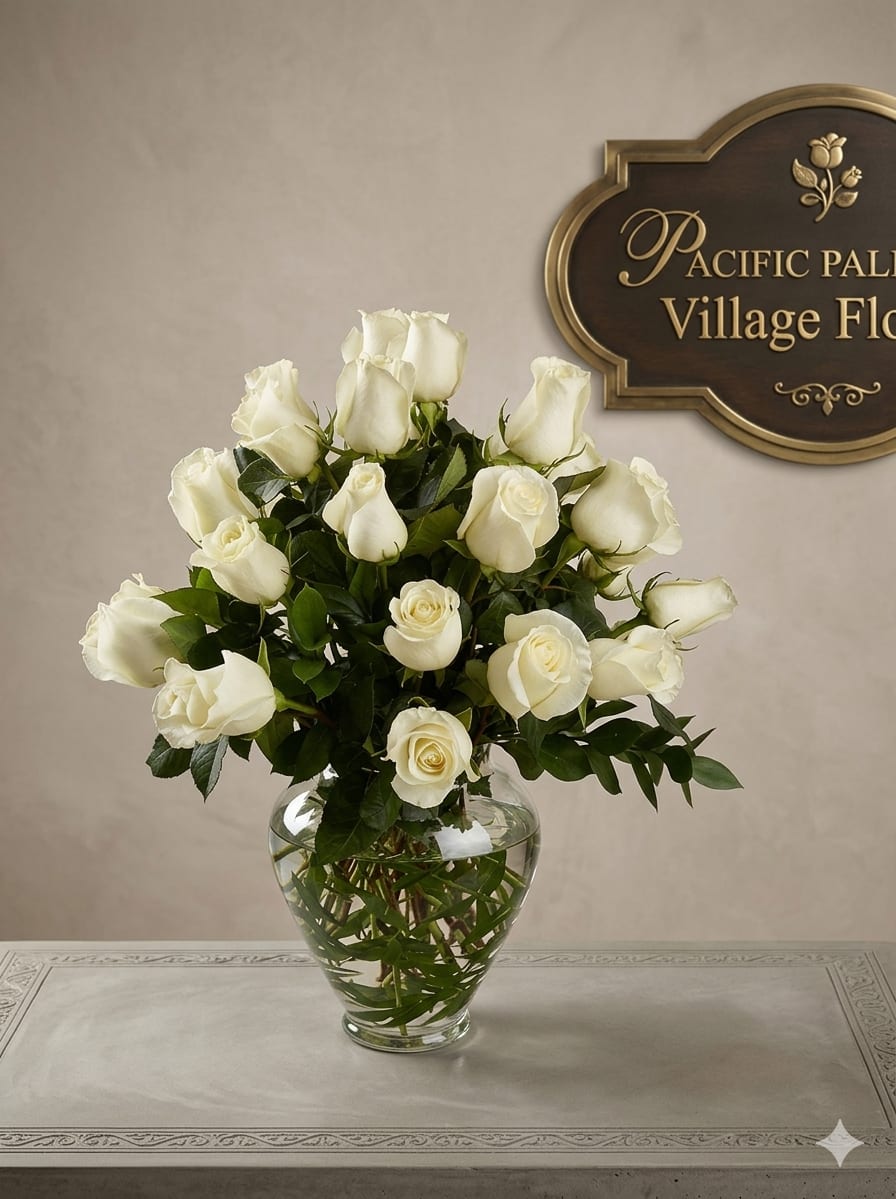 Tres Chic - A timeless, elegant arrangement of pristine white roses gathered in a classic glass vase, accented with rich green foliage. The design is simple yet sophisticated, emphasizing the natural beauty and purity of the roses in a clean, balanced presentation.
