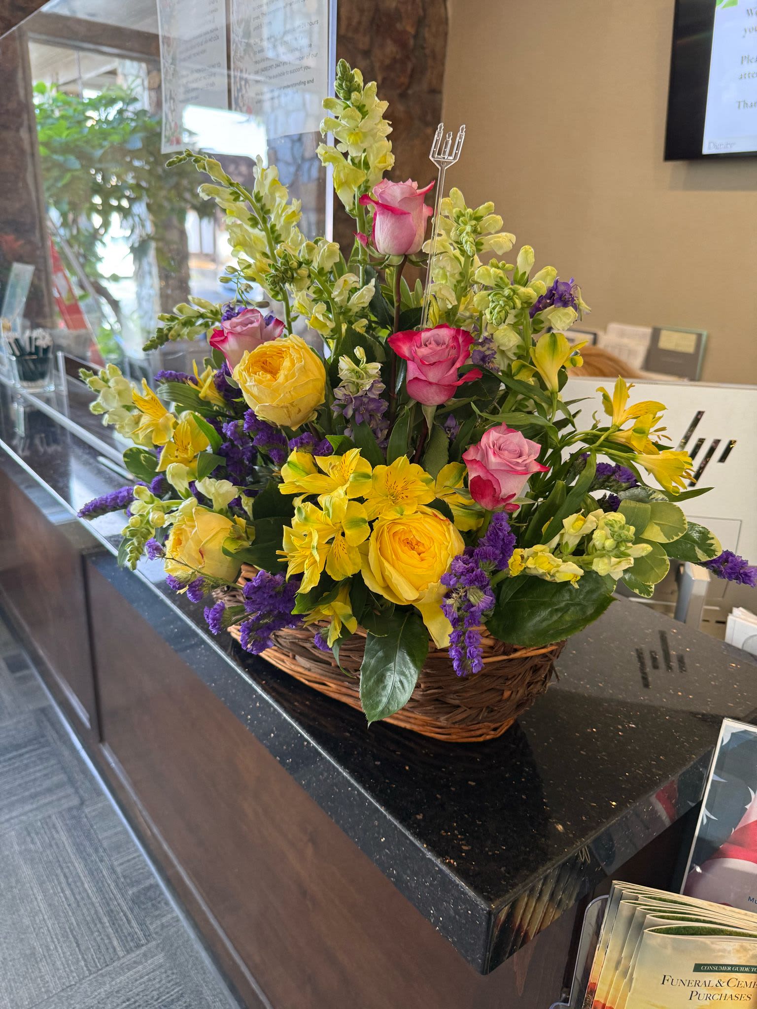 Basket arrangement of yellow and pink roses with yellow lilies and white snapdragons