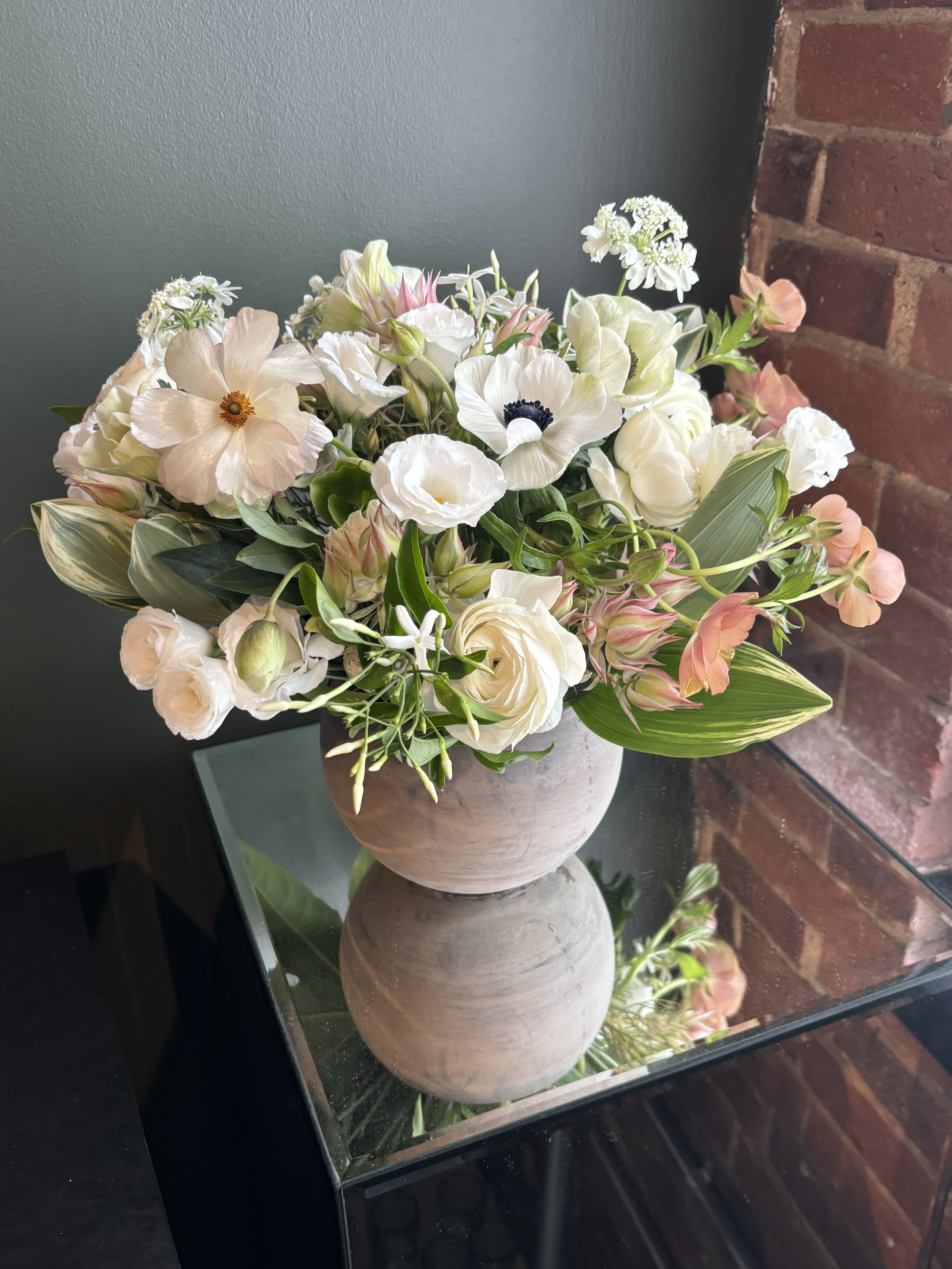 The Tess - The Tess is beautifully designed with premium blooms consisting of White ranunculus, butterfly ranunculus, white lisianthus, anenomes, jasmine