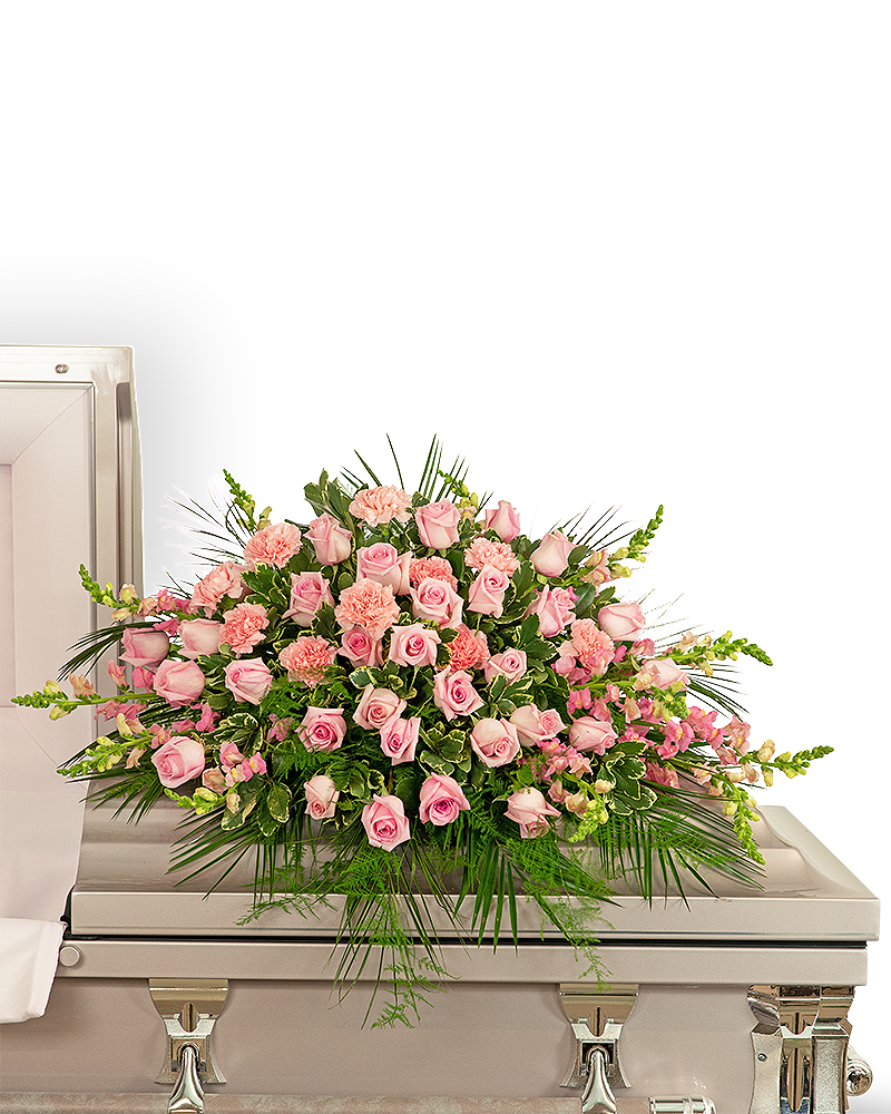 Forever Adored Casket Spray - Pink carnations symbolize thoughts of remembrance, while pink roses are a sign of appreciation and grace. We bring together these beautiful pink flowers in a stunning design we call our Forever Adored Casket Spray. It features delicate pink roses, carnations, snapdragons, Emerald, Plumosa, and premium foliage. The casket spray is typically provided by the spouse or immediate family as a heartfelt memorial from the family and is designed to sit on the lid of the casket for a funeral service or memorial.