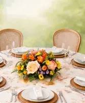 Sweet &amp; Simple Peach - There’s just something about soft peach tones that makes a table feel warm, welcoming, and full of life. This sweet arrangement blends beautiful roses, tulips, and ranunculus in gentle peach shades, brought to life with a cheerful touch of sunny yellow daisies. It has that lighthearted, easygoing feel that makes everyone feel right at home—simple, fresh, and full of charm.  Just right for a small to medium table, it’s a lovely way to brighten the room and bring a little extra joy to your gathering. 