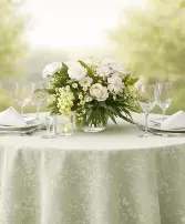 Spring Fling  - Spring at Kiko’s is always a little fun, a little busy, and full of life—and this sweet centerpiece captures that feeling perfectly. Designed in soft greens and fresh whites, it brings that carefree spirit of the season right to your table.  Featuring white tulips, ranunculus, cheerful daisies, and delicate chamomile, all gently accented with light green mini hydrangea, this piece feels fresh, natural, and full of warmth.  Just right for a table of 2, 4, or even 6, it’s an easy, beautiful way to gather family and friends together.  A perfect little touch for your table—at a comfortable, everyday price.