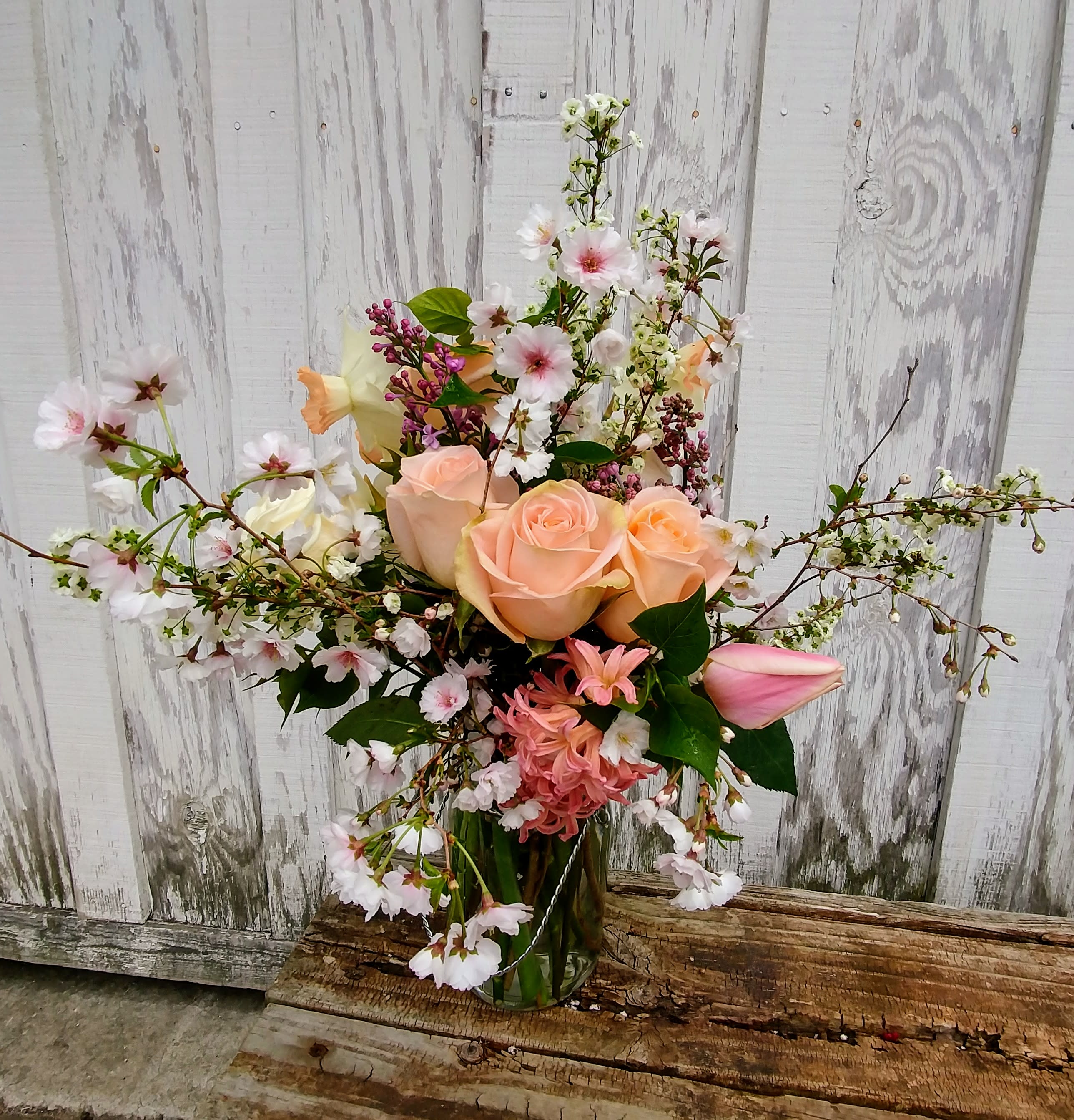 Soft Spring Time - Cherry blossoms, roses, tulips, hyacinths and daffodills make a beautiful display!  All of our arrangements are custom made to order. We grow many of the flowers we use in our arrangements organically on the property. The flowers used are dependant on what we have available seasonally. 