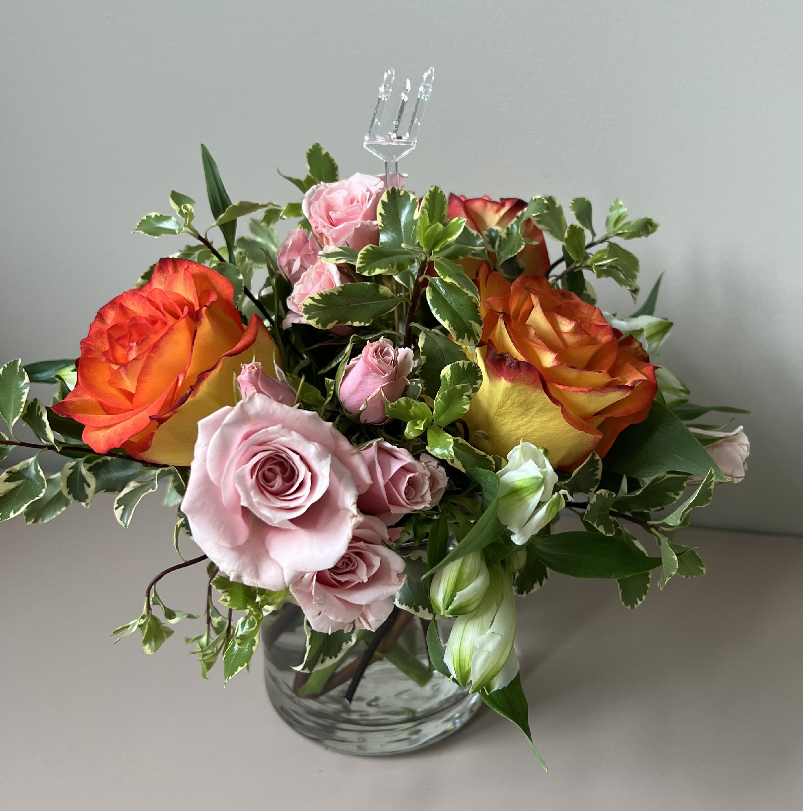 Weekly Blooms Special - Our special of the week features pink spray roses, two toned orange and yellow roses and alstromeria arranged in a petite cylinder vase 