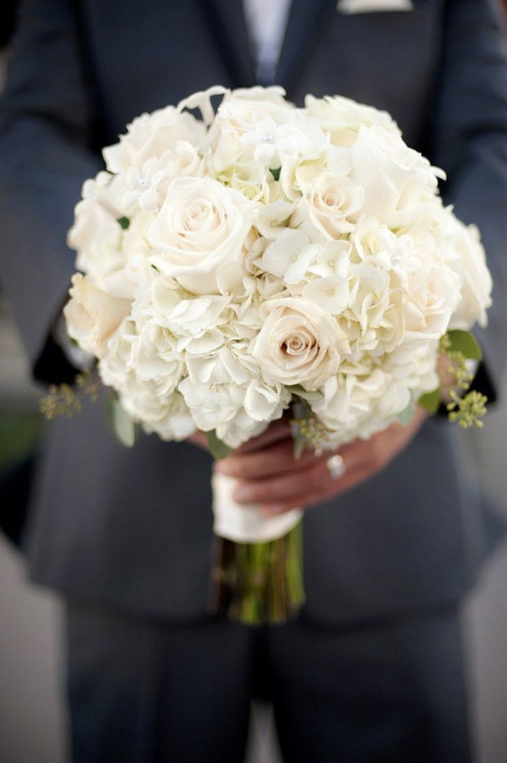 Bridal Bouquet "Regal" - A timeless, romantic bouquet of ivory roses and white hydrangea with soft greenery accents. Lush, elegant, and beautifully textured—perfect for brides seeking classic beauty with a refined, modern touch. Open ends wrapped with ivory satin ribbon.