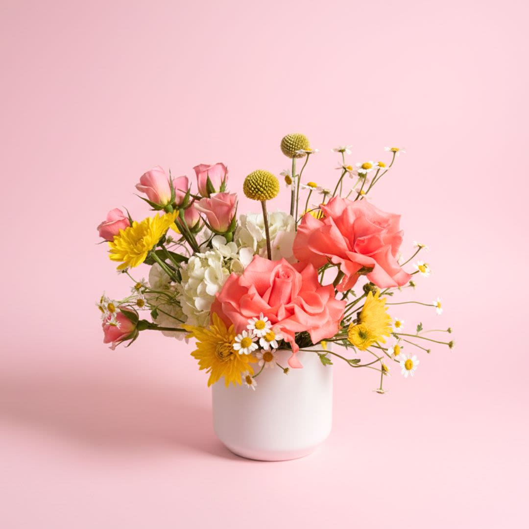 Marge Simpson  - "Well, if loving my kids is lame, then I guess I'm just a big lame"- Marge Simpson   Show your mom how much you love them with our bright and cheery floral arrangement! Vibrant  yellow, coral, white, and orange flowers arranged in a white ceramic vase.   Mother's Day Delivery- Due to the volume of arrangements, delivery times can not be guaranteed over the Mothers Day holiday.  We'd prefer not to leave arrangements outside so please let Mom know something is coming. 