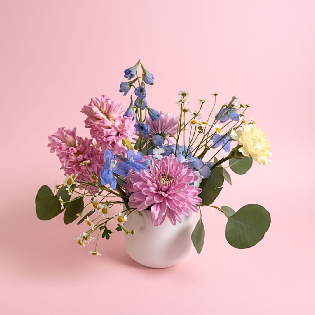 Mom's Favorite  - We all know who Mom's Favorite is... Be your Mom's #1 and send her a beautiful arrangement of pastel blue, pink, yellow, and purple flowers arrangement in a white ceramic vase.   Mother's Day Delivery- Due to the volume of arrangements, delivery times can not be guaranteed over the Mothers Day holiday.  We'd prefer not to leave arrangements outside so please let Mom know something is coming. 