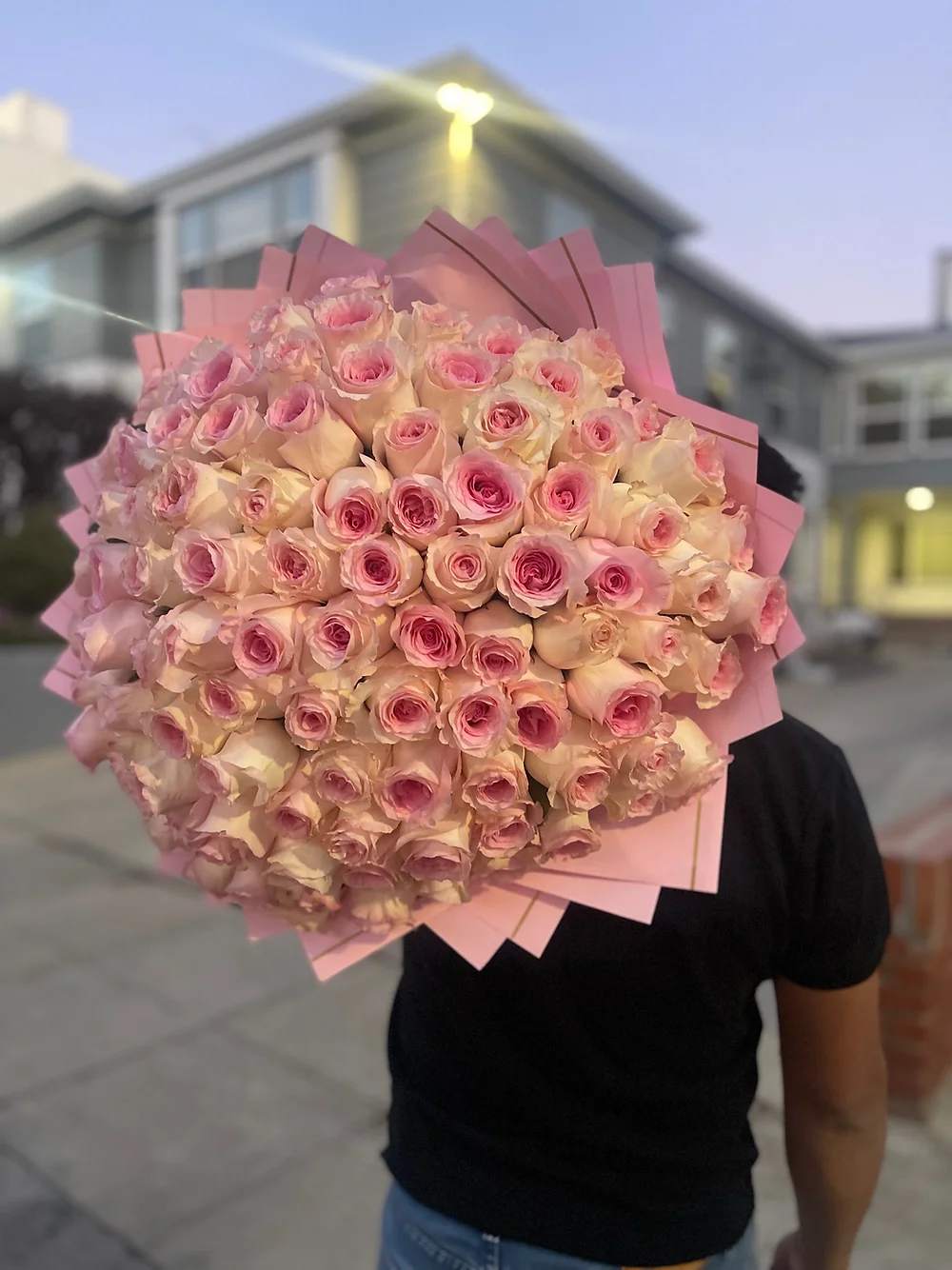 Large round bouquet of pale pink roses wrapped in layered pink paper