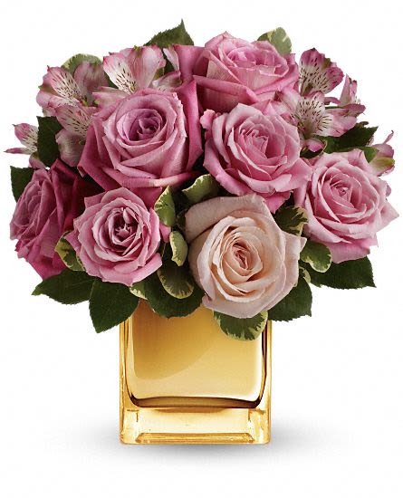 A Radiant Romance - Make her blush with the beautifully blushing blooms of this romantic bouquet. Arranged inside a golden mirrored cube that catches the light and radiates your love, it''s a heartfelt gift she''ll always remember! This bouquet is rich in roses and alstroemeria in soft shades of pink and lavender -variegated pittosporum gives texture and greenery. Delivered in a golden mirrored cube vase to add a luxurious touch. Approximately 10 1/2" W x 11 1/2" H This item is hand-arranged and delivered by our florist. All prices in U.S. Dollars.
