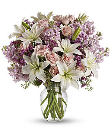 Blossoming Romance - Think of someone you love. Then think how thrilled they''ll be when this gorgeous bouquet arrives at the door. Light pink spray roses, fragrant white lilies and other favorites in a sparkling glass vase - they''ll be floating on air all week. This lovely bouquet includes light pink spray roses, white asiatic lilies, lavender stock and lavender waxflower accented with assorted greenery. Delivered in a glass rose vase. 