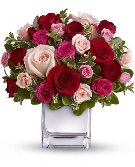 Love Medley Bouquet with Red Roses - Sing her a love song with flowers. This lush, loving rose arrangement tells her just how much you care. The stylish bouquet features red and pink roses accented with spray roses in shades of red and pinks. Delicate green oregonia and pittosporum add a fresh contrast. The flowers are delivered in our exclusive Mirrored Silver Cube vase.