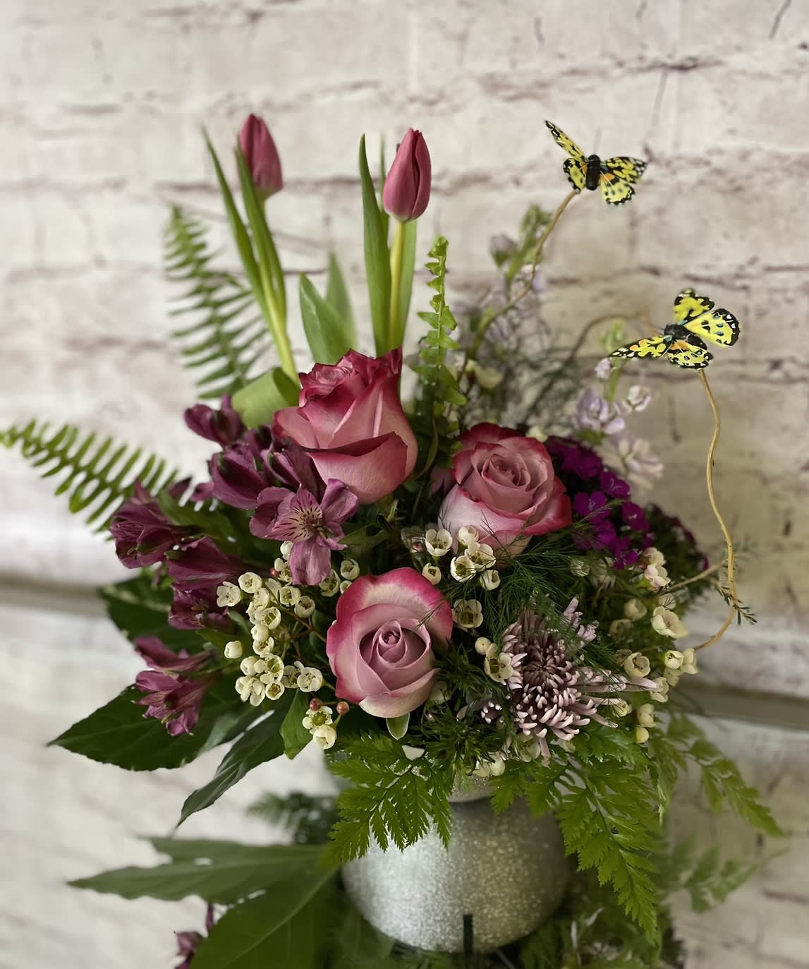 "BETHANY" - This adorable butterfly garden design is filled with roses, Fuji mums, tulips, and premium foliage and accent flowers. 