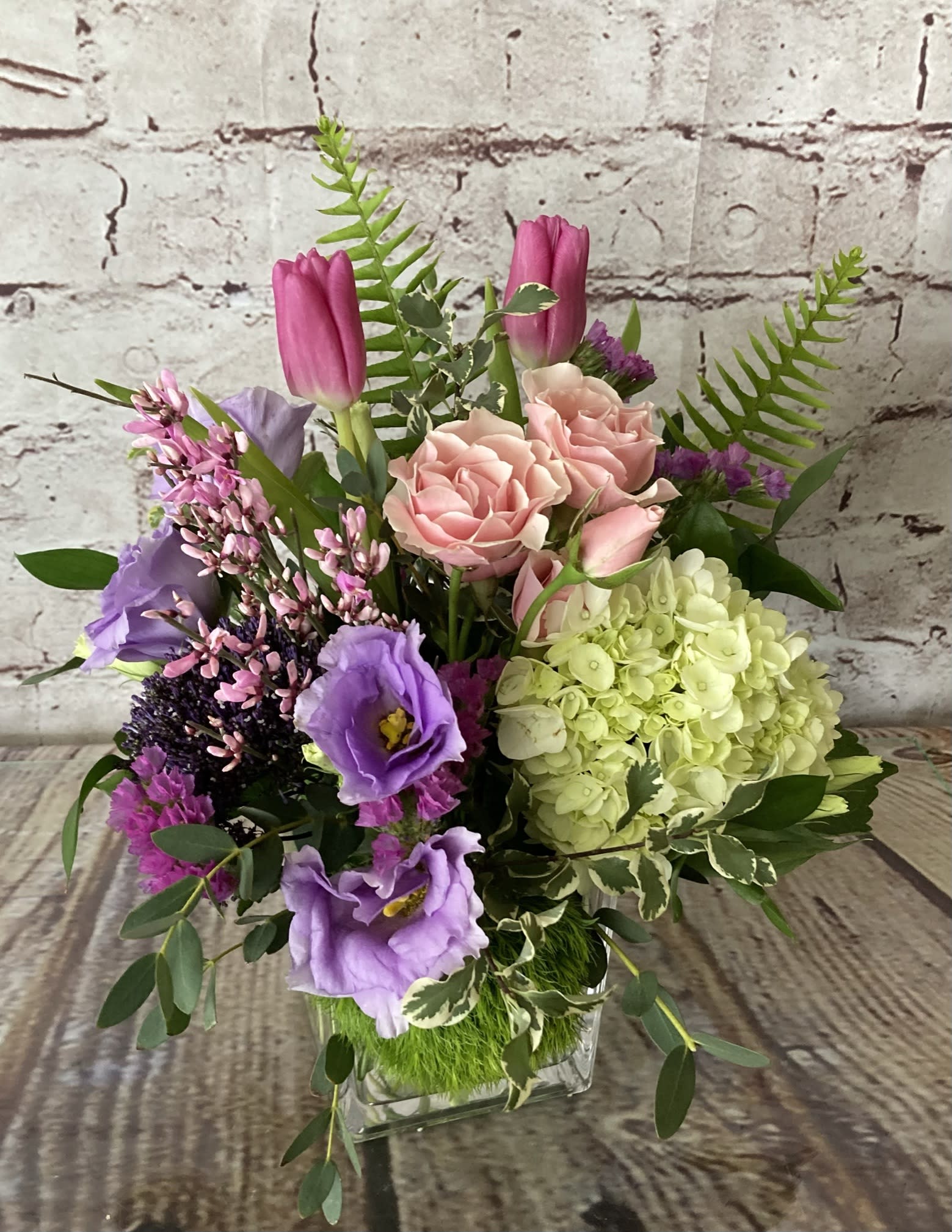 "DEBORAH" - A vase overflowing with roses, hydrangea, alstromeria, lisianthus and premium foliage.  Some blossoms are seasonal, and will be substituted.