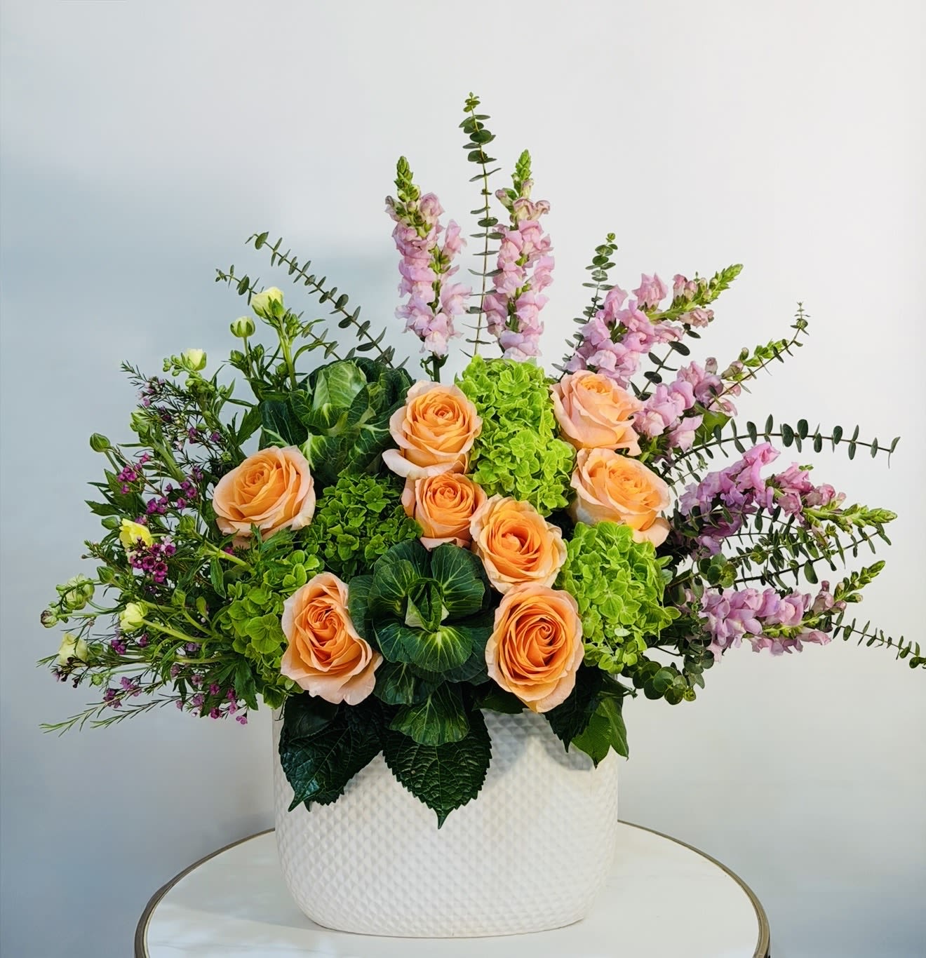 Golden Garden - A stunning and vibrant floral arrangement featuring premium peach roses, fresh green hydrangeas, and delicate seasonal blooms in soft pink tones. Designed in a modern white ceramic vase, this arrangement brings together warmth, elegance, and natural beauty  perfect for any occasion, from birthdays to special celebrations or simply to brighten someone’s day. At Guy Floral Studio, we specialize in creating unique, handcrafted floral designs using only the freshest flowers. This arrangement is thoughtfully styled to create a balanced, full, and luxurious look that stands out in any space. We proudly offer same day flower delivery in Beverly Hills, Bel Air, West Hollywood, Beverly Grove, Santa Monica, Culver City, Studio City, Encino, Sherman Oaks, Hollywood Hills, and surrounding Los Angeles areas.   