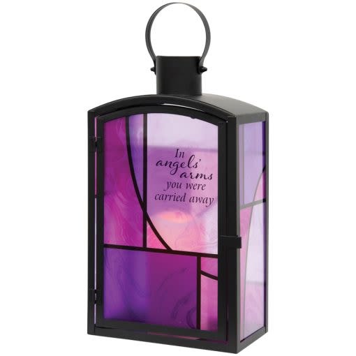 "In Angels Arms" Lantern - Our stained-glass lanterns are made with high-quality black finish, amid beautiful stained glass style artwork and a charming flameless LED candle. They are weather friendly! 3 AAA batteries are NOT included. Lantern Quote Reads: "In angels' arms you were carried away"  W: 8" H: 14" D: 4.5"