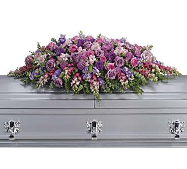 Long pink and purple casket spray arrangement on a silver casket