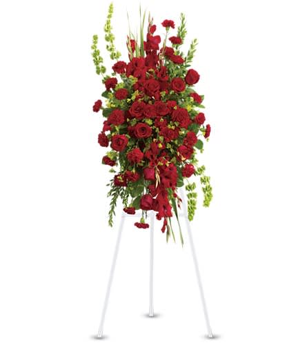Tall red rose and carnation standing spray with green accents on a white easel