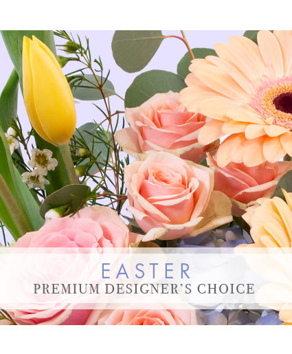 Pastel Easter arrangement with pink roses, a yellow tulip, and a peach gerbera daisy in close-up view