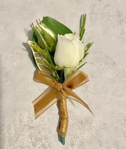 White rose boutonniere with gold ribbon bow on a light background