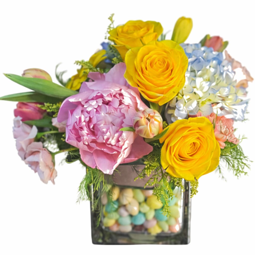 Jumping Jellybeans Bouquet - A playful burst of springtime color and sweetness! The Jumping Jellybean Bouquet features vibrant yellow roses, lush pink peonies, soft blue hydrangea, and delicate seasonal accents, all beautifully arranged in a clear glass vase filled with cheerful pastel jellybeans. This design brings together fresh florals and a fun candy twist—perfect for Easter celebrations, spring birthdays, or simply brightening someone’s day.  Whimsical, colorful, and full of joy—this bouquet is guaranteed to make hearts (and smiles) jump!  Perfect for: Easter, spring gifting, kids &amp; families, or anyone who loves a sweet surprise.