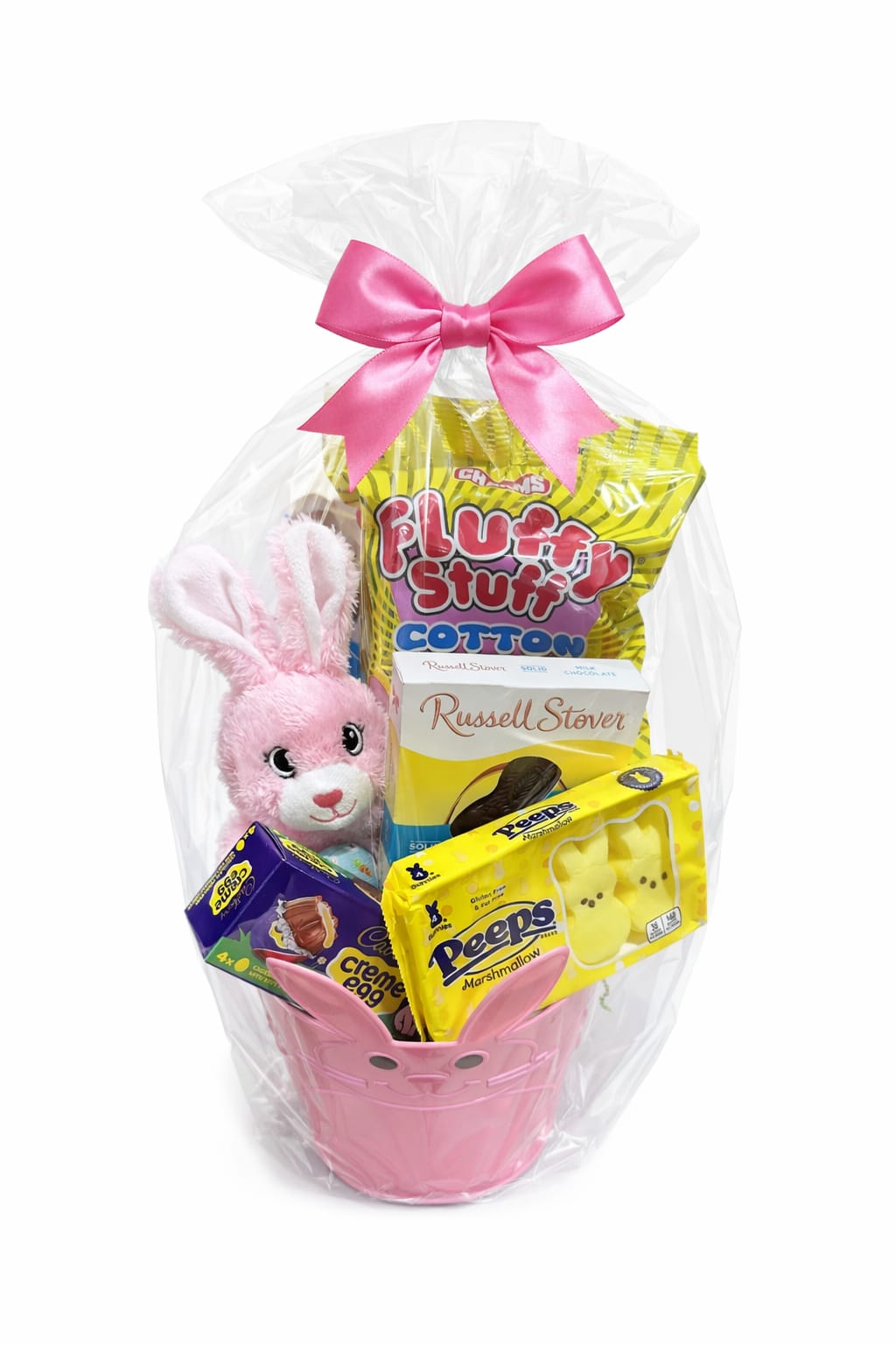 Pretty in Pink Easter Basket - Make her Easter extra sweet with our Pretty in Pink Easter Basket — a cheerful collection of treats and cuddles she’ll absolutely adore. This adorable pink bunny basket is filled with festive favorites, including fluffy cotton candy, classic chocolate treats, marshmallow Peeps, and everyone’s favorite Cadbury Creme Eggs. A soft plush bunny peeks out, adding a keepsake touch she can enjoy long after the sweets are gone.  Wrapped beautifully in clear cellophane and finished with a soft pink bow, this basket is ready to gift and guaranteed to bring smiles. Perfect for daughters, granddaughters, or anyone who loves a little pink and a lot of sweetness.  Includes: • Plush pink bunny • Cotton candy • Russell Stover chocolate • Peeps marshmallows • Cadbury Creme Eggs • Decorative pink bunny basket • Wrapped with cello and finished with a pink bow
