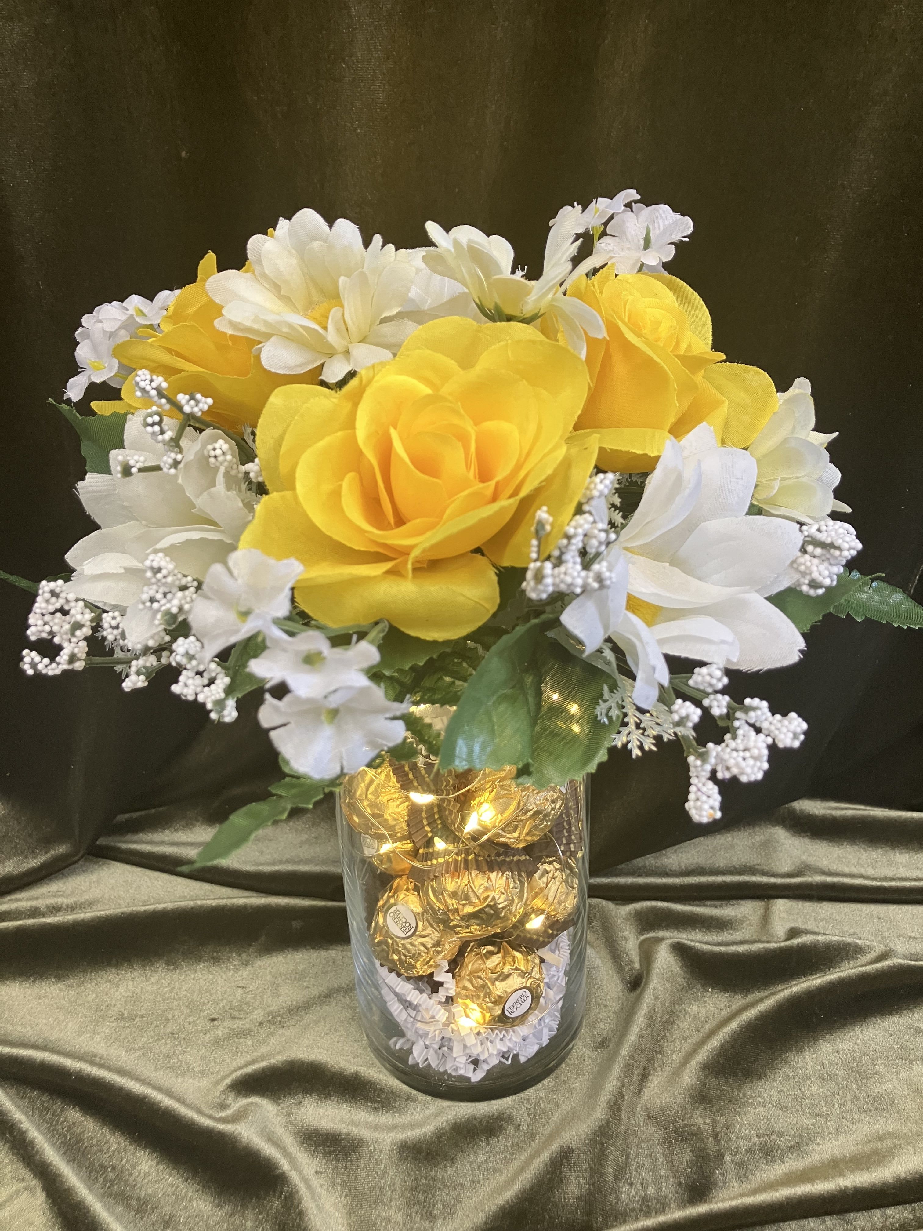 Cute Silk Flowers  - Fun and cute silk flower arrangement combined with chocolates and tea lights in a cylinder vase. As pictured 