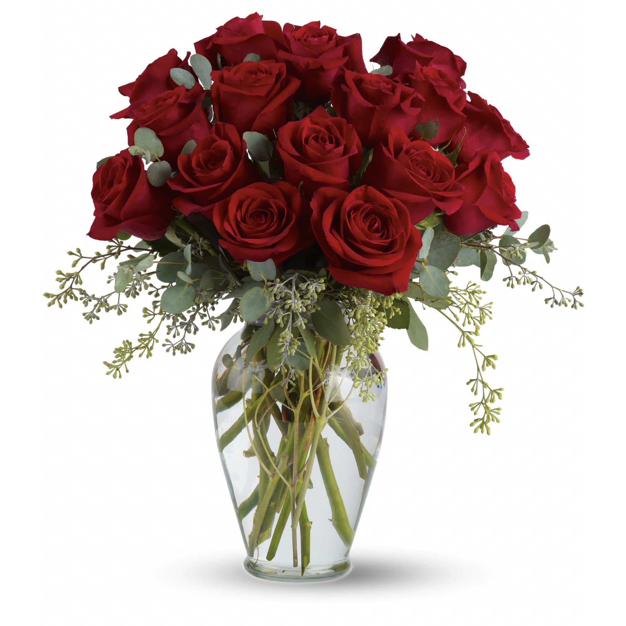 Arrangement of long-stem red roses in a clear glass vase with water.