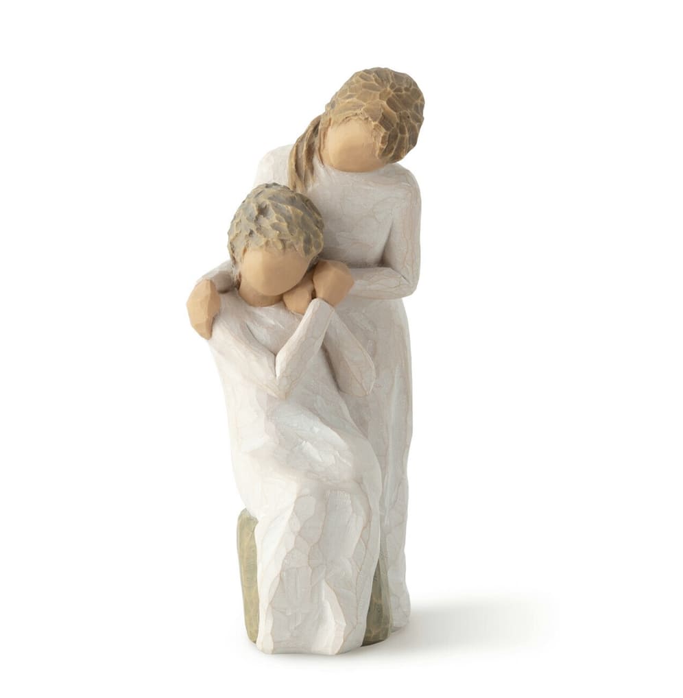 Two carved figurines in white robes embracing