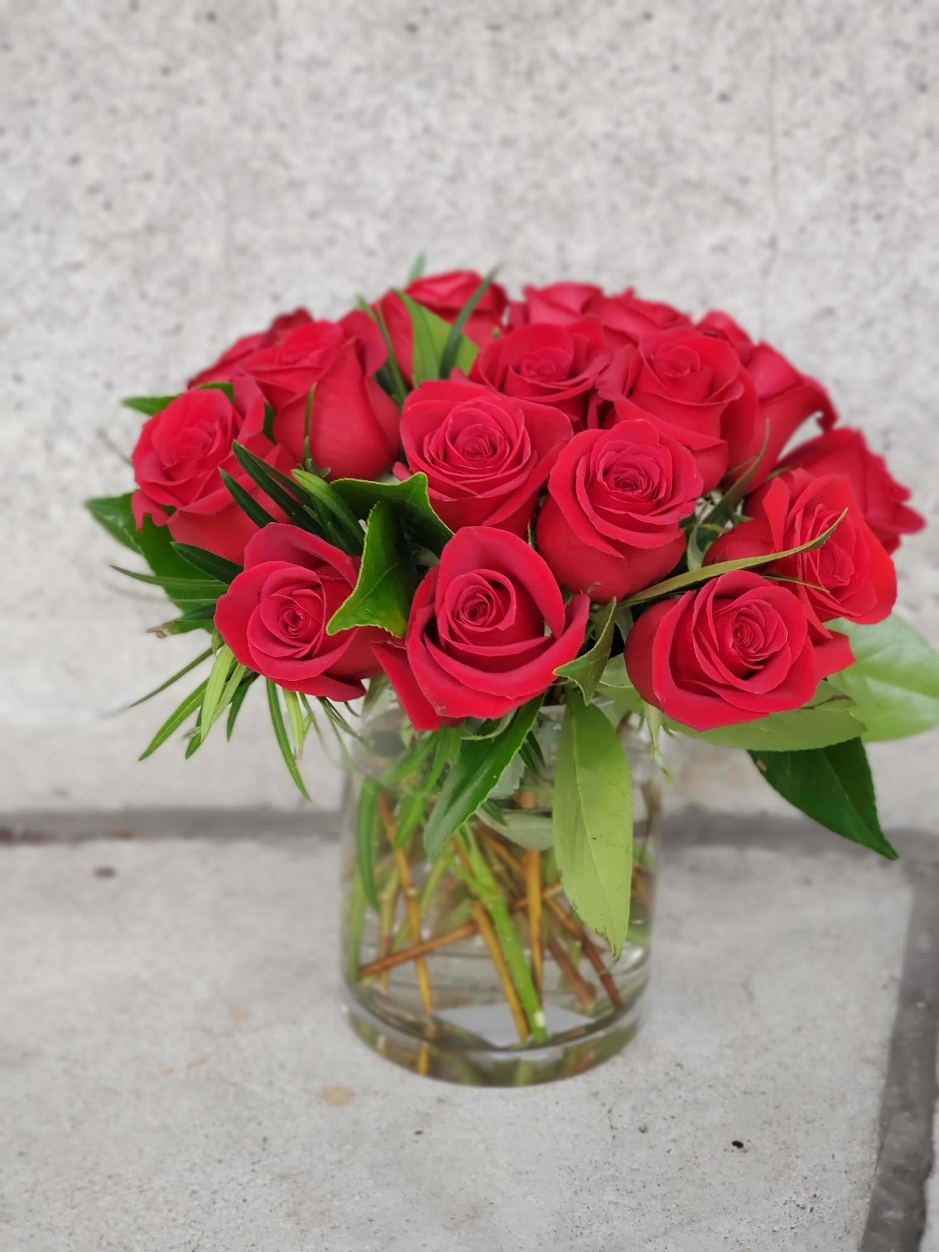 Arrangement of red roses tightly clustered in a clear glass vase