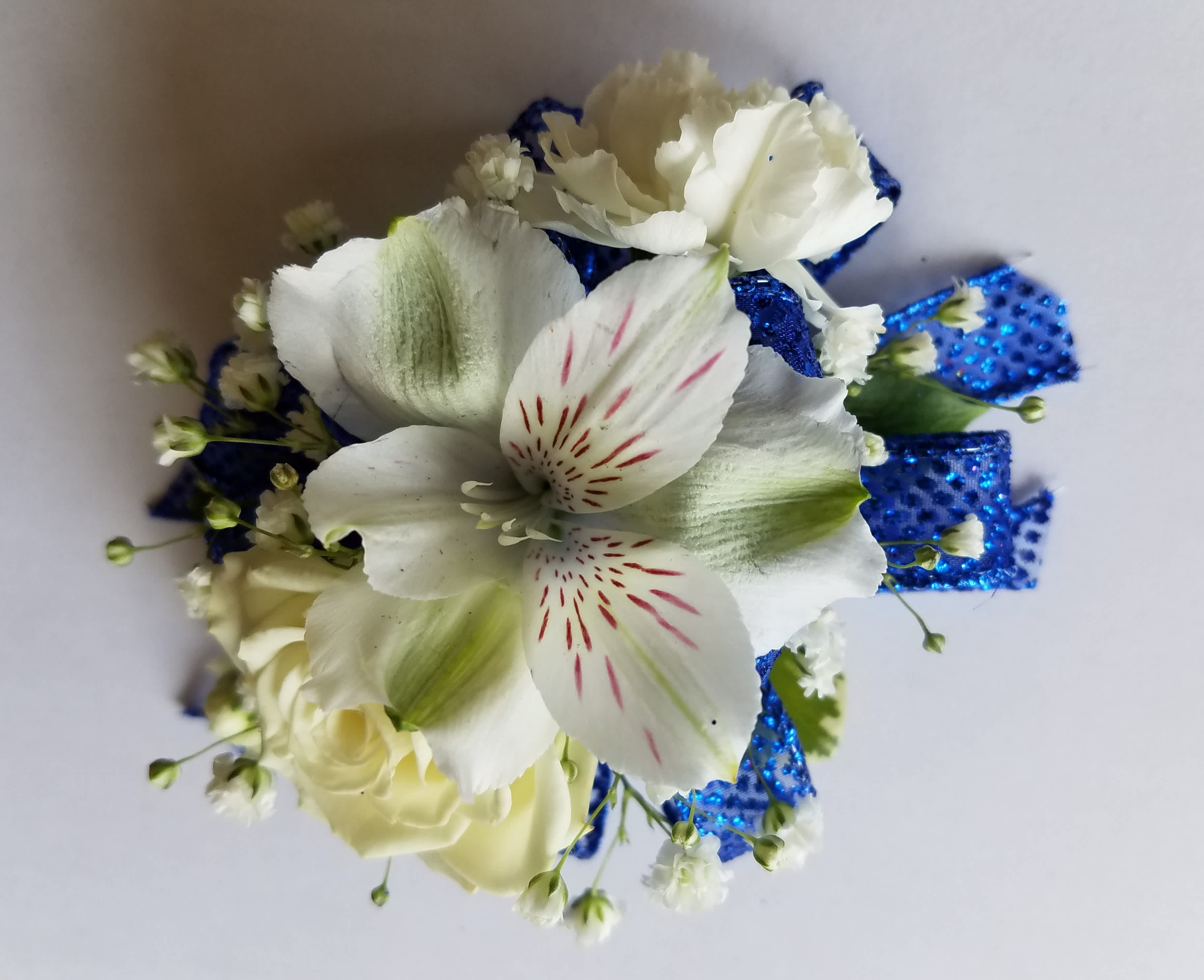 Corsage 3 Mixed Flowers - This corsage has 3 mixed designers choice flowers with greens and filler. We have all sorts of ribbon from lime green sparkle to animal print, just tell us in the special instructions what your looking for! You may also send us a picture of your dress or inspirations to our email address lvfloral@gmail.com just make sure to include your name and order number.   ALL corsage/boutonniere orders will be ready for PICK UP ONLY between 12pm-4pm the day of the event. 