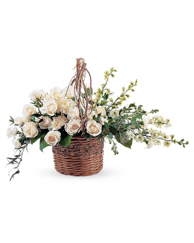 Low wicker basket of ivory roses and white blossoms with trailing vines and twig handle.