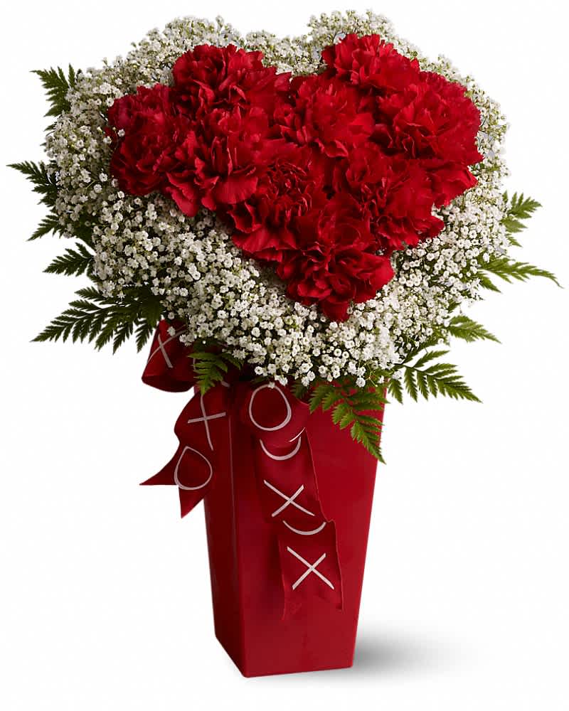 Tall red vase with a heart of red carnations framed by white filler flowers and ribbon