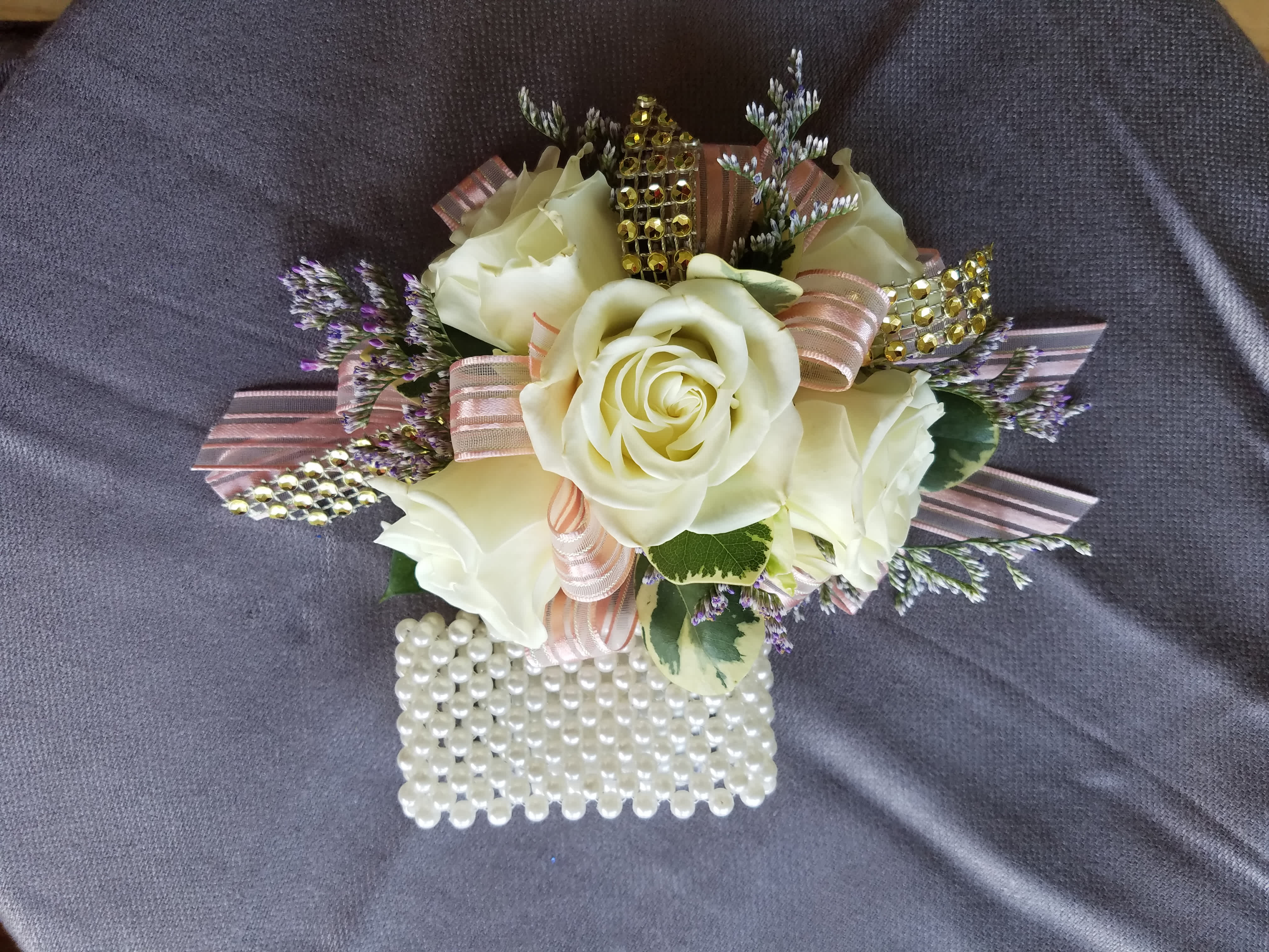 Corsage 5 Rose Premium  - This corsage has 5 spray roses of common colors with greens, filler, upgraded bling, and an upgraded bracelet. We have all sorts of ribbon from lime green sparkle to animal print, just tell us in the special instructions what your looking for! You may also send us a picture of the dress or inspirations to our email address lvfloral@gmail.com just make sure to include your name and order number.    ALL corsage/boutonniere orders will be ready for PICK UP ONLY between 1pm-4pm the day of the event. 